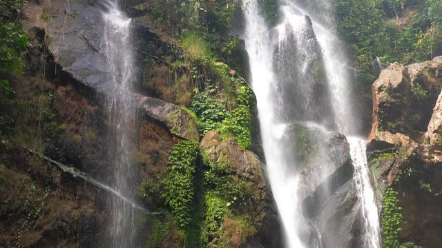 Amazing waterfall hidden in the tropical rainforest jungle in the form of a pirate skull and bones on background amazing wild nature