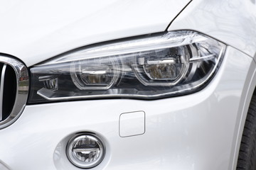 Fototapeta na wymiar shiny headlight on a white car