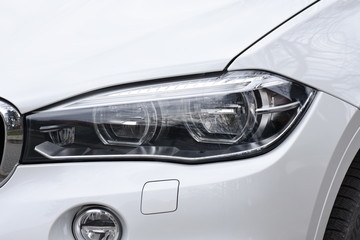 Fototapeta na wymiar shiny headlight on a white car