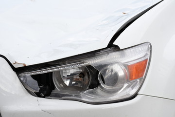 broken car headlamp  on a white car