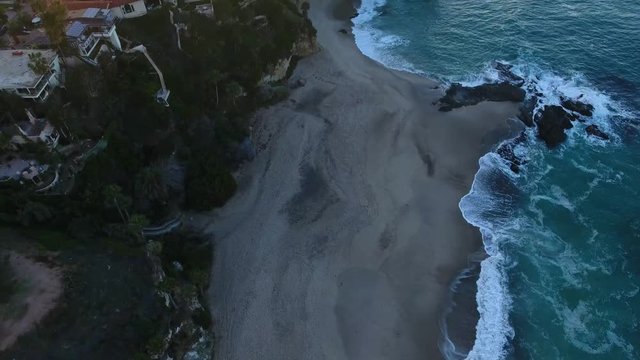California, United States, Aerial view of beach houses along Pacific Coast in California. Real estate during sunset. From above, drone flying over water.