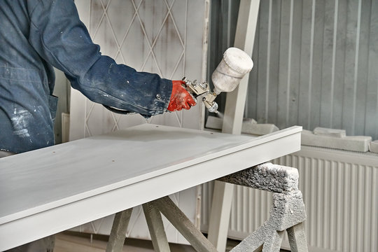 Painting cabinets with spray gun . Painting chamber, spray gun. Furniture manufacture.
