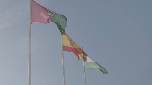 Flag of Spain and the cities Granada and Malaga are moving in the wind.