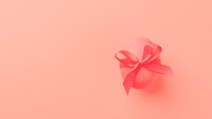 Easter egg on a trendy coral color background. Festive concept. Minimalism. Copy space.