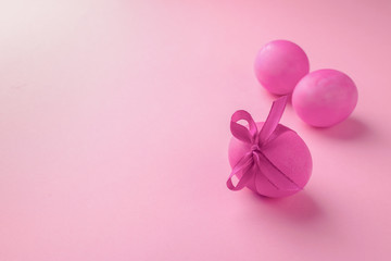 Easter pink eggs on a smooth pink background. Festive concept. Minimalism. Copy space. Selective focus.
