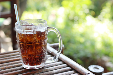 glass of water with ice cubes on wooden table