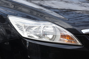 Car'sCar exterior detail.shiny headlight on a black  car exterior detail, headlight on a  new car