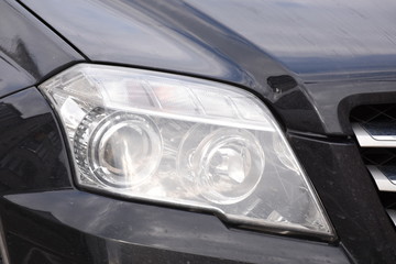 Car'sCar exterior detail.shiny headlight on a black  car exterior detail, headlight on a  new car