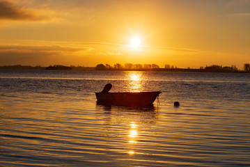 Naklejka na ściany i meble sunset on the sea and a little boat