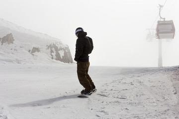 Snowboarder on top of the mountain before the start of the descent. Lifestyle