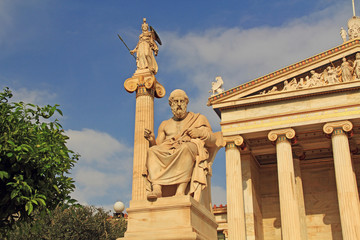 Statues of Plato and Athena at the National Academy of Arts in Athens, Greece with blue sky copy space.