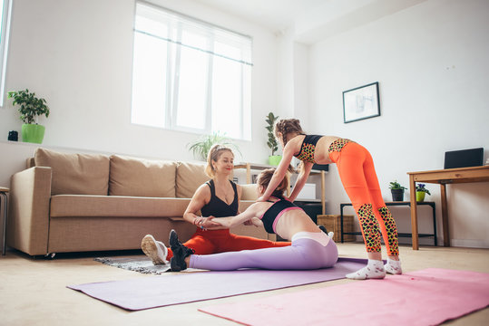 Fit females exercising and stretching at home