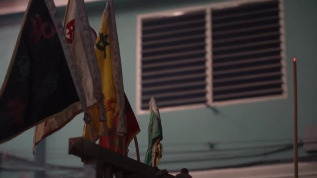 Flags representing different temples and spirit gods on truck driving to the temple for spirit ascension