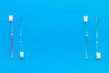 Oral hygiene. Plastic toothbrushes on blue background top view space for text