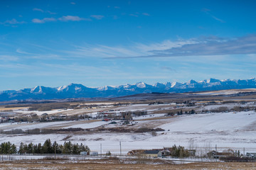 fields landscape with mountains on the horizon in winter