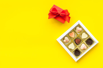Sweets for Valentine's day near red gift box on yellow background top view space for text
