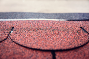Biberschindeln aus Bitumen auf einem kleinen Dach eines Gartenhauses