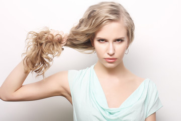 portrait of a young woman holding her long curly healthy hair