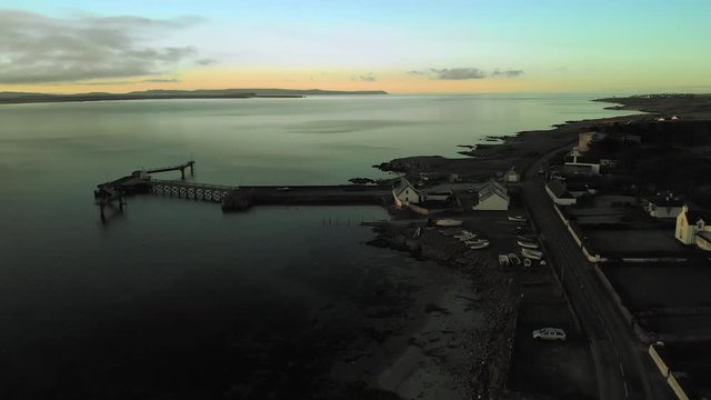 Aerial shot on the Iles of Islay, a Whisky region located in the Hebrides, Scotland, UK. This one shows a wooden landing dock next to Bruichladdich Distillery.