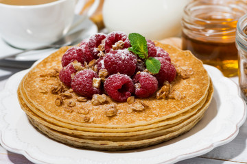 traditional sweet pancakes with fresh raspberries for breakfast on wooden table, closeup
