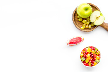 Healthy diet concept. Fruit salad near fresh fruits on white background top view space for text