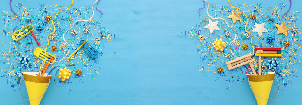 Purim celebration concept (jewish carnival holiday) over wooden blue background.