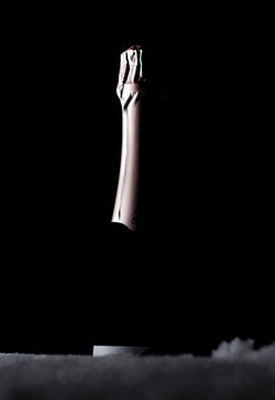 ottle of champagne on black background on snow 