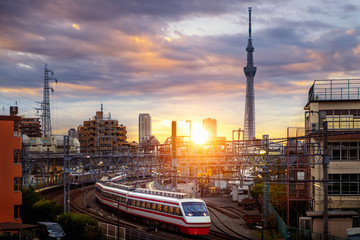 Train in city in Tokyo with sunset background