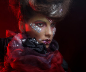 Close up portrait young woman with bright fantasy make up over red background
