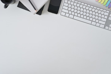 Flat lay top view office desk. Workspace with keyboard and office supplies with coffee on white table.