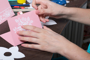 Making greeting cards from paper, cardboard and tape. Woman artisan at work.