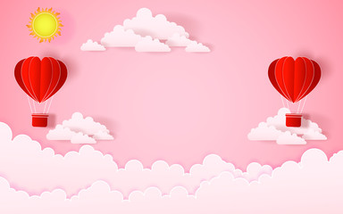 Obraz premium The hot air heart balloon, sun and countryside on pink sky as love, happy valentine's day, wedding and paper art concept