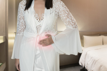 The woman in silk nightwear and white robe wake up for go to the bedroom, Women with menstrual disorders at night, Menstrual cramps, Irritable Bowel Syndrome or IBS