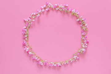 flat lay of Flower crown ,floral wreath circle made from pink flowers isolated on pink background, top view. flower creative composition with copy space
