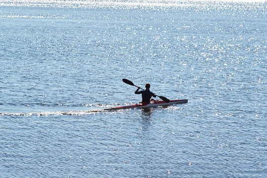 A man in a diving suit on a kayak floats