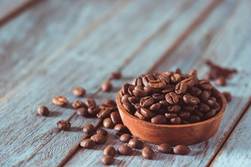 Coffee beans on wooden texture and background, using color grading effect