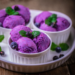 Scoops of blueberry ice cream on a white ceramic plate