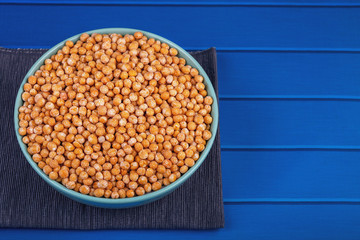 pea seeds closeup in a ceramic bowl on a wooden background