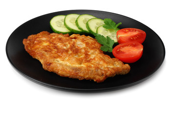 schnitzel with tomato and cucumber on black plate isolated on white background