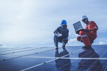 engineers operating and check generating power of solar power plant on solar rooftop; technical...