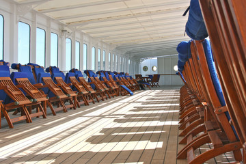 Hölzerne Sonnenliegen auf Luxuskreuzfahrtschiff Wooden teak deck chairs or sun loungers on outdoor...