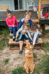 Fototapeta premium Family and dog on the steps of the house