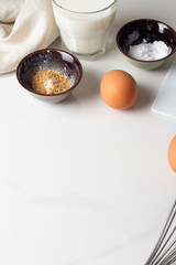 eggs, baking powder, orange peel, milk on a white background.