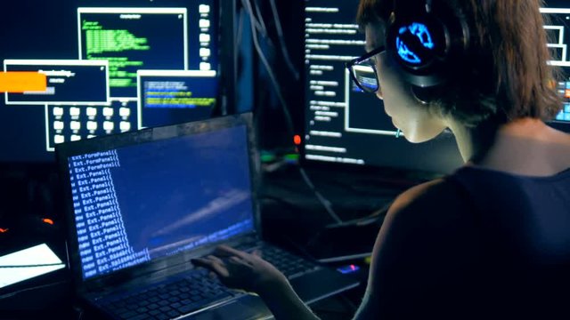 Girl types on a laptop, hacking system. Cyber crime and hacking concept.