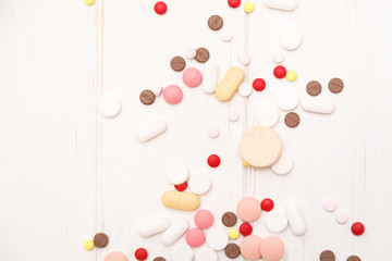 pills on a white wooden background