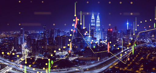 Beautiful Kuala Lumpur skyline at night with financial chart state blend in effect .