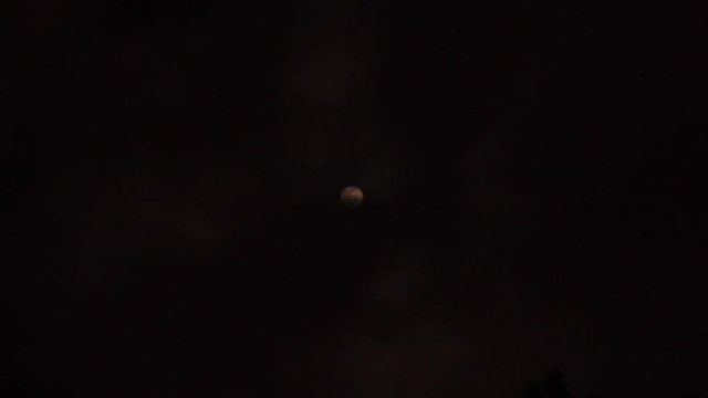 Extreme zoom photo of moon at night with deep dark clouds and strong wind