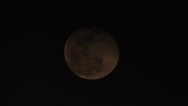 Extreme zoom photo of moon at night with deep dark clouds and strong wind