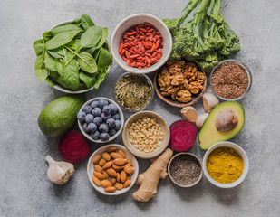 Healthy clean food - vegetables, fruits, nuts, superfoods on a gray background. Healthy eating concept. Top view.