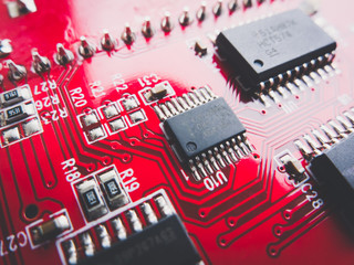 Circuit board in red with electronic components. Electronic circuit board. 